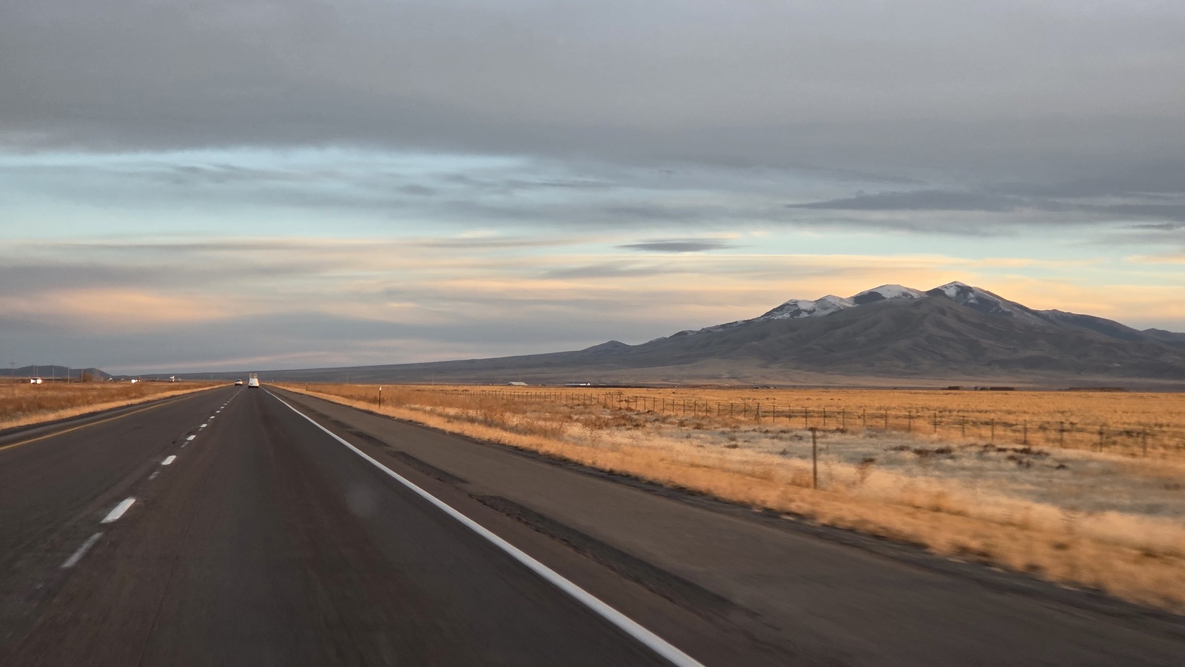 Southern Idaho highway at sunset with snow-capped mountains