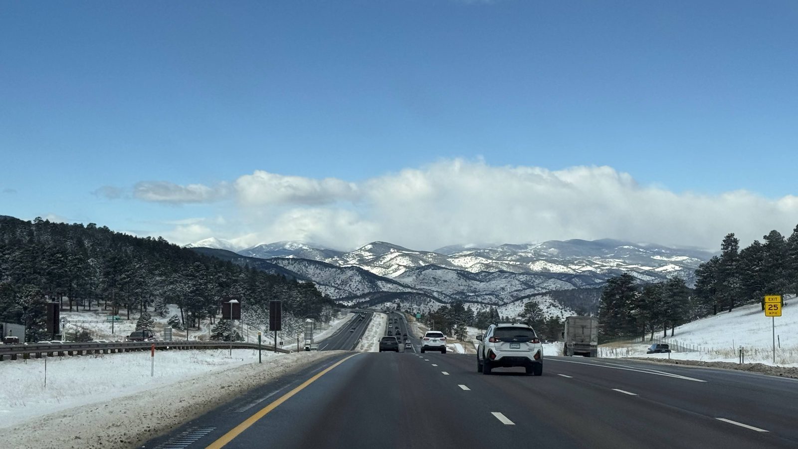 I-70 westbound leaving Denver with snowy Rockies ahead