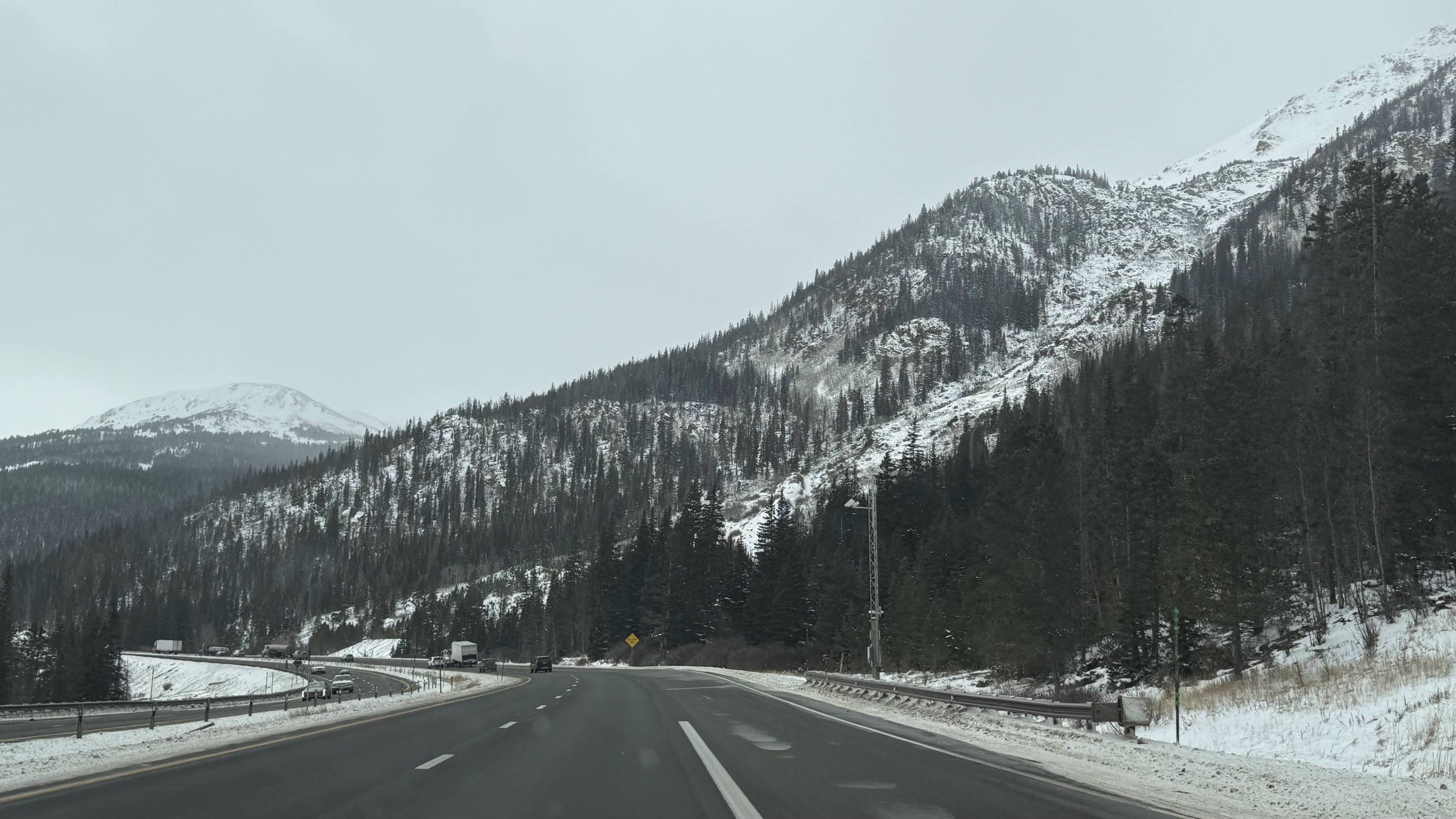 I-70 near Vail Pass with snow-covered mountains and pine forests